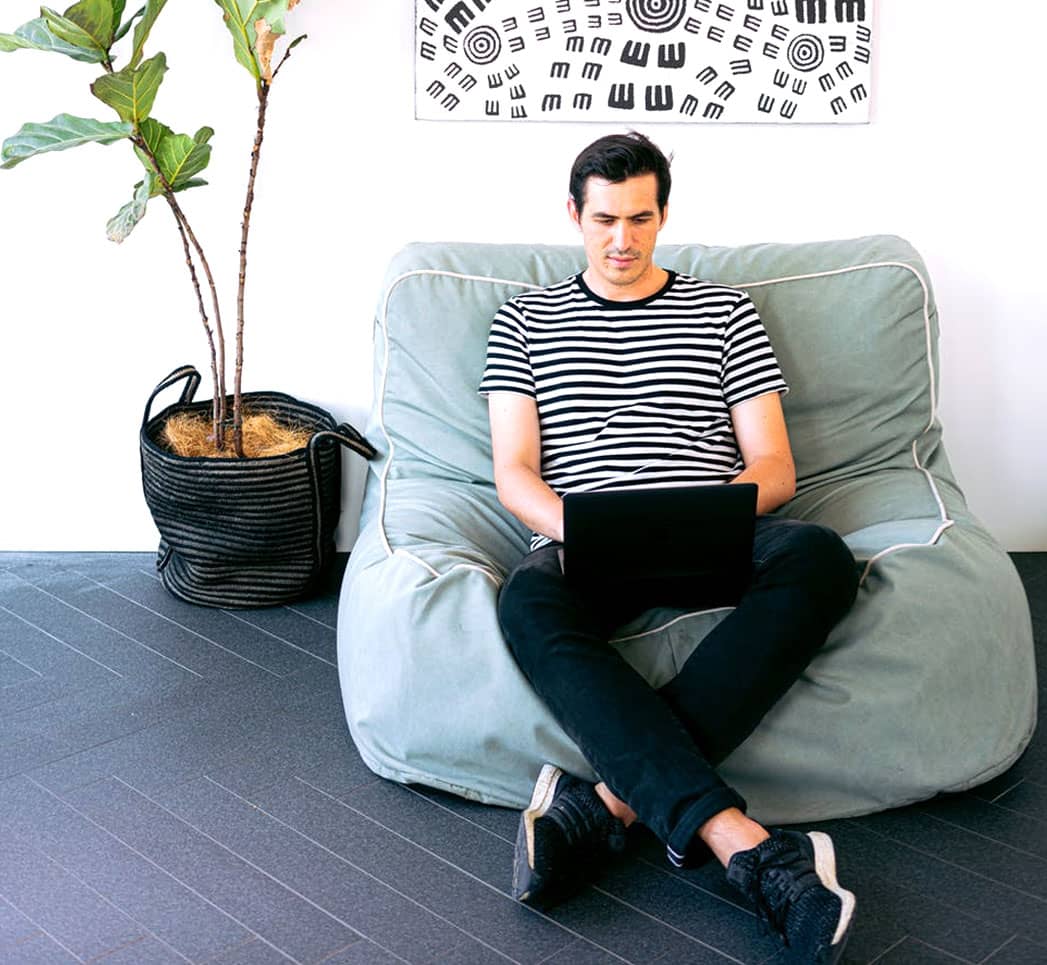 A man sitting on top of a bean bag chair.