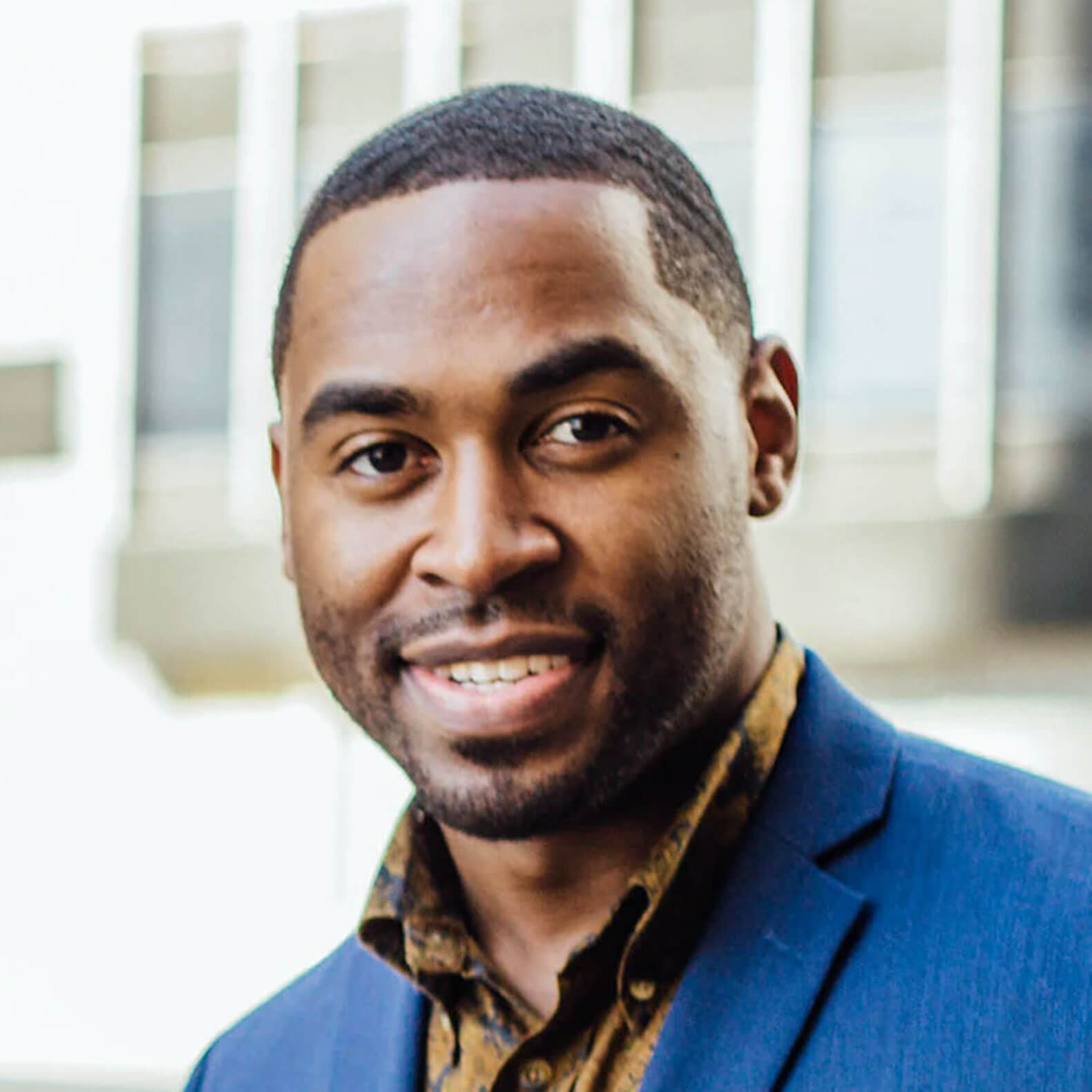 A man in a blue suit and brown shirt.