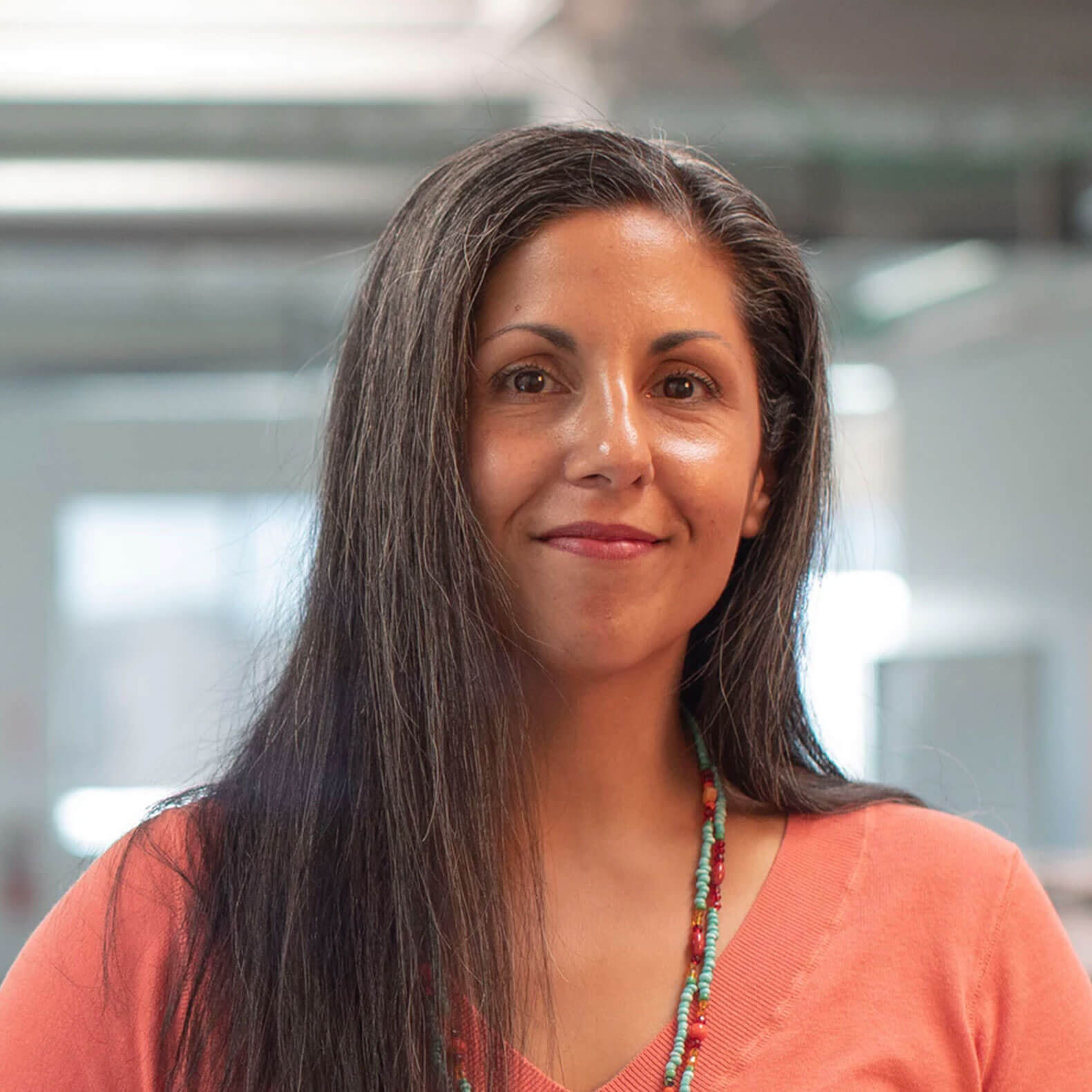 A woman with long hair and a necklace.
