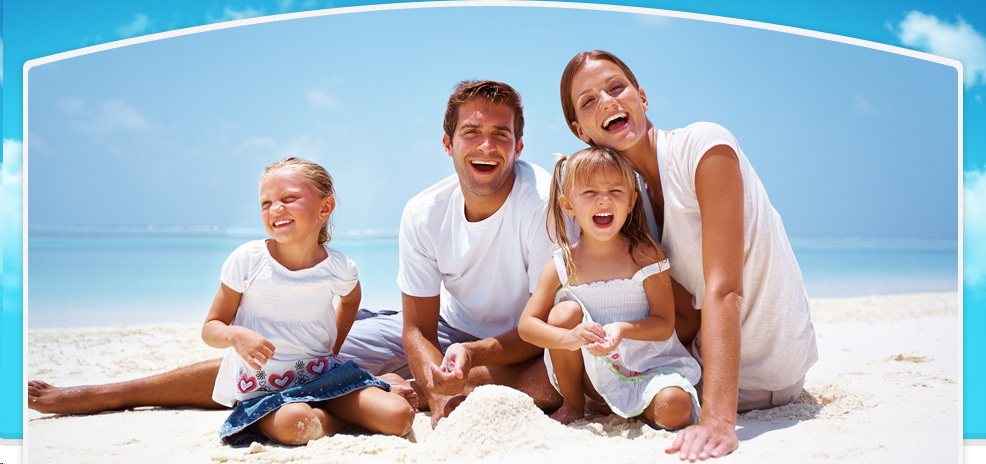 A family sitting on the beach posing for a picture.